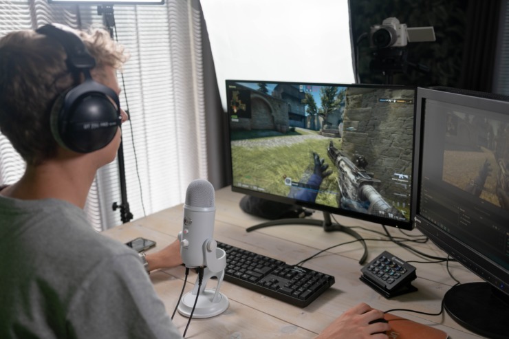 A Gen Z gamer uses a gaming PC and microphone.