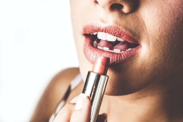 A woman applies lipstick