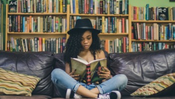 A girl sits and reads a book