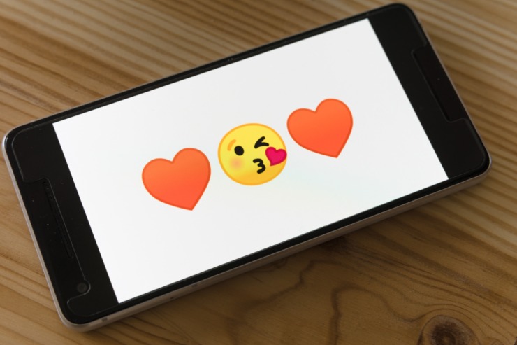 Phone screen with emoji hearts and face