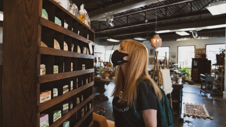 A girl browses in store, wearing a mask