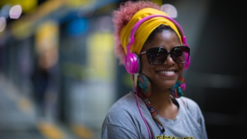 a woman smiles while listening to headphones