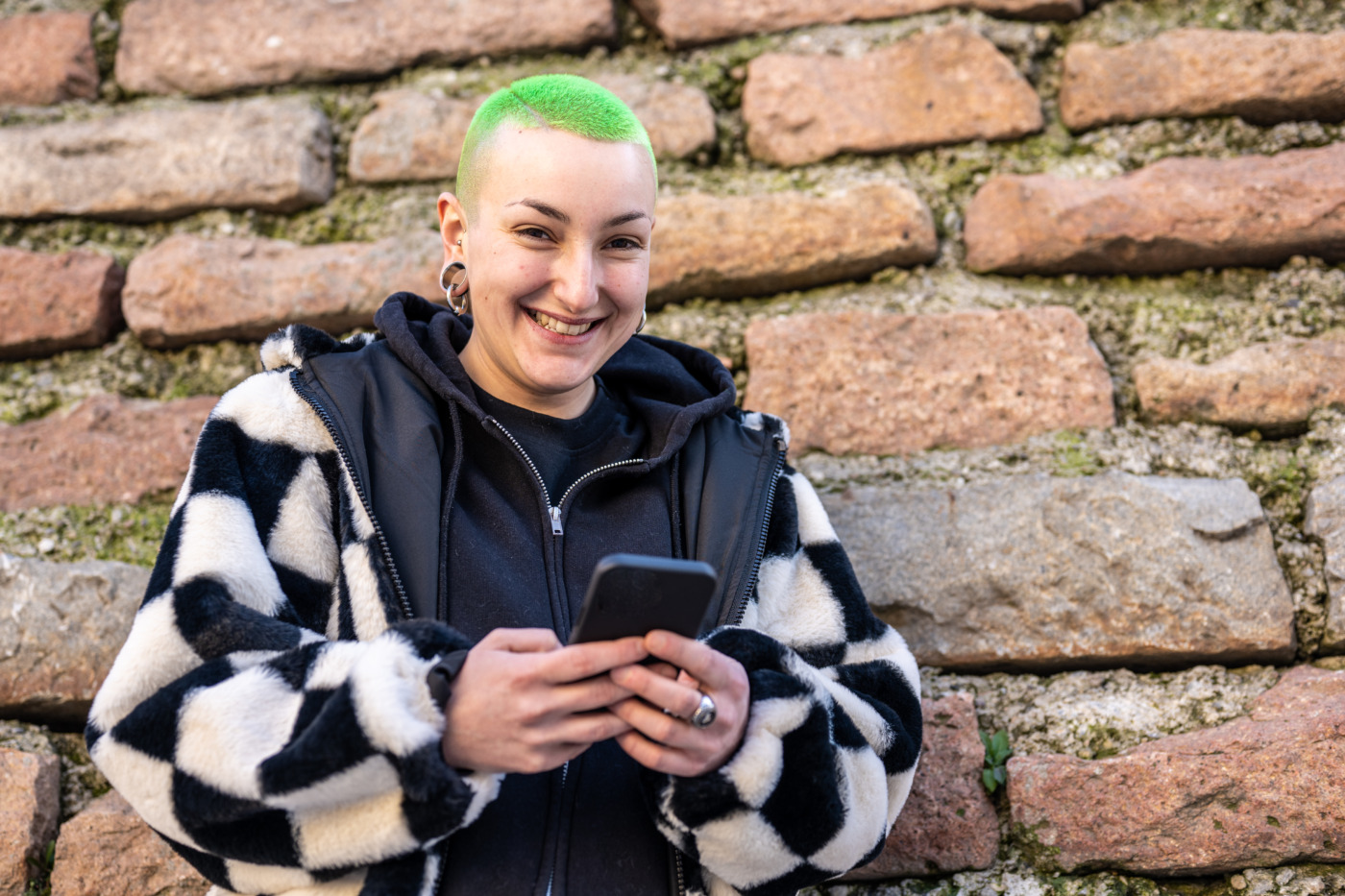 portrait of young person with green hair on their phone 
