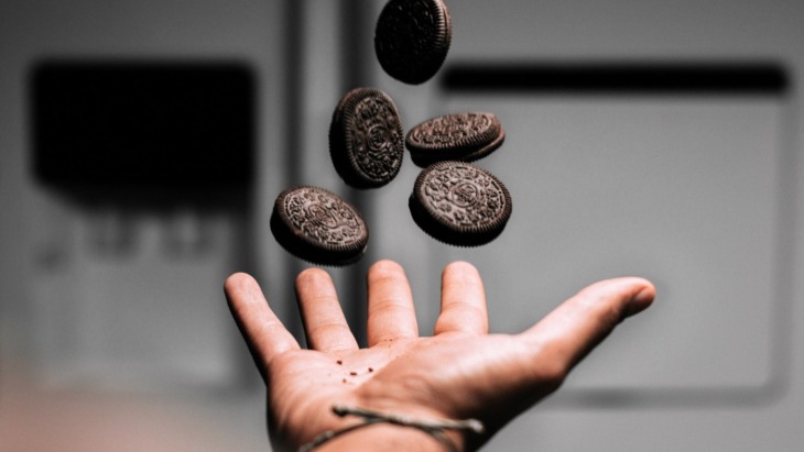 person throwing five Oreo cookies in the air