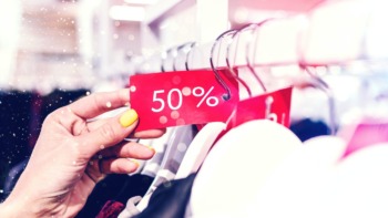 person holding a 50% off sale tag