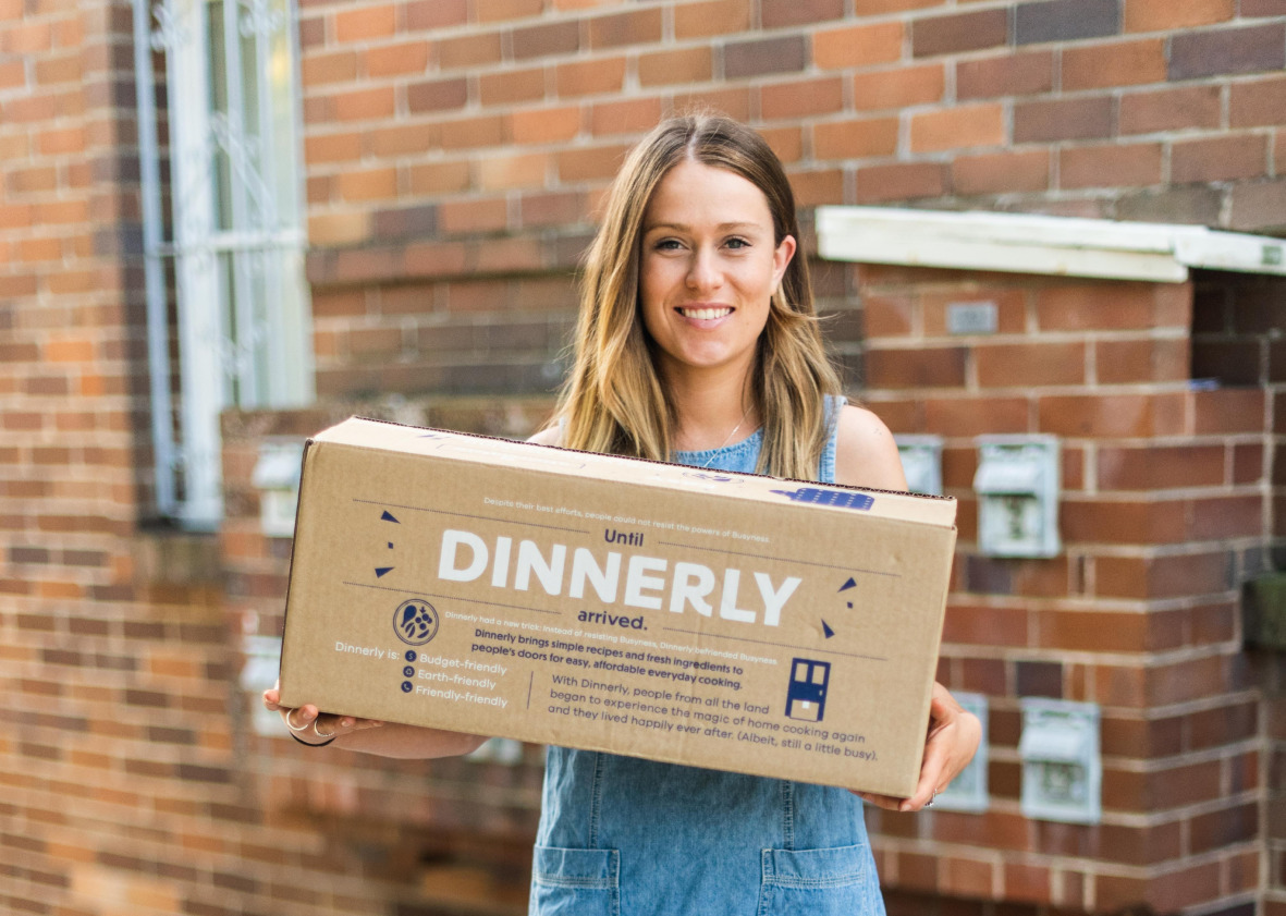 A girl holds a Dinnerly delivery box