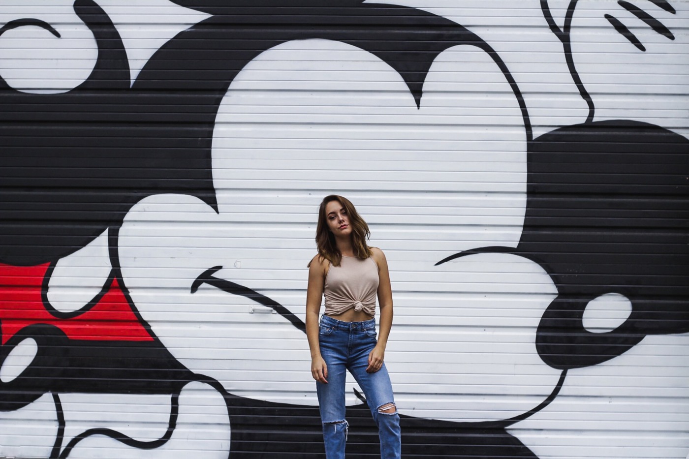 female stood in front of a Mickey Mouse wall painting 