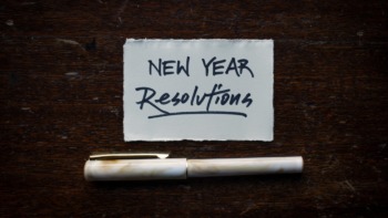 Pen and paper with 'New Year Resolutions' written on it