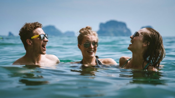 Three people in the sea laughing