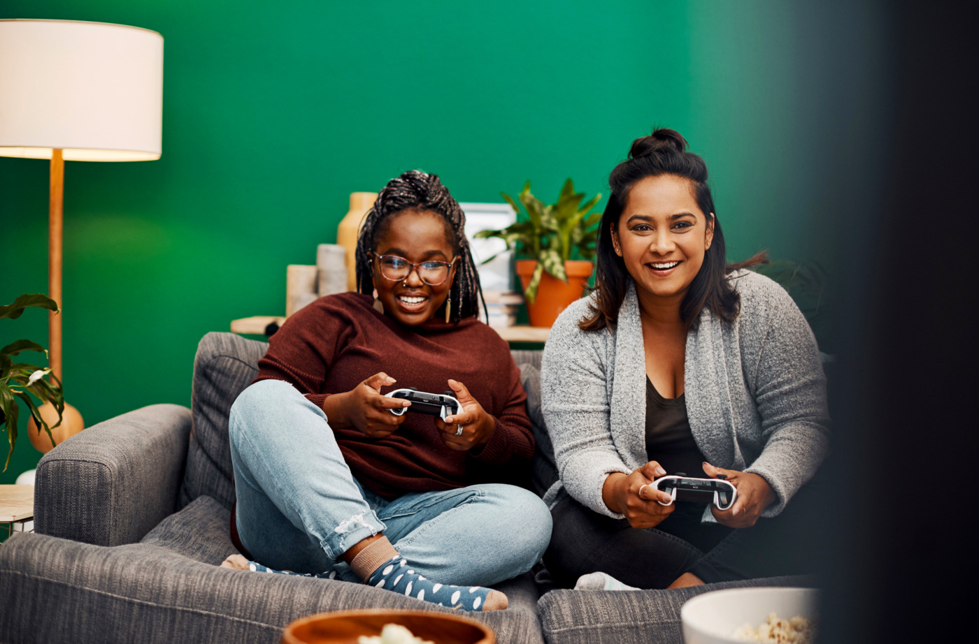 Shot of two young women playing video games on the sofa at home