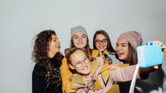 Photo of a smiling teenage girls having fun while celebrating