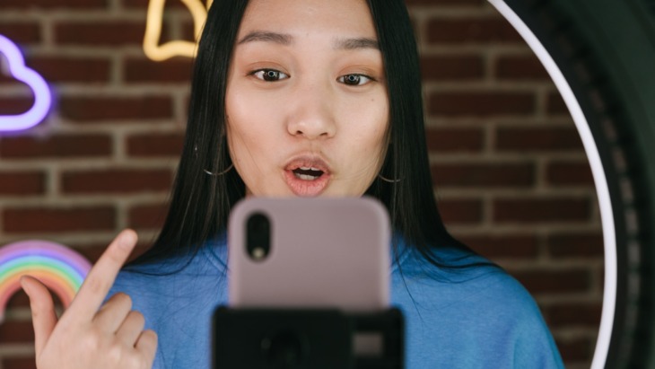 Female Social Media Creator Recording Herself with a Smartphone